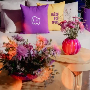 Evento empresarial realizado pela Glue - Aiqfome: Aniversário 18 anos, Ambiente decorado com almofadas Aiqfome